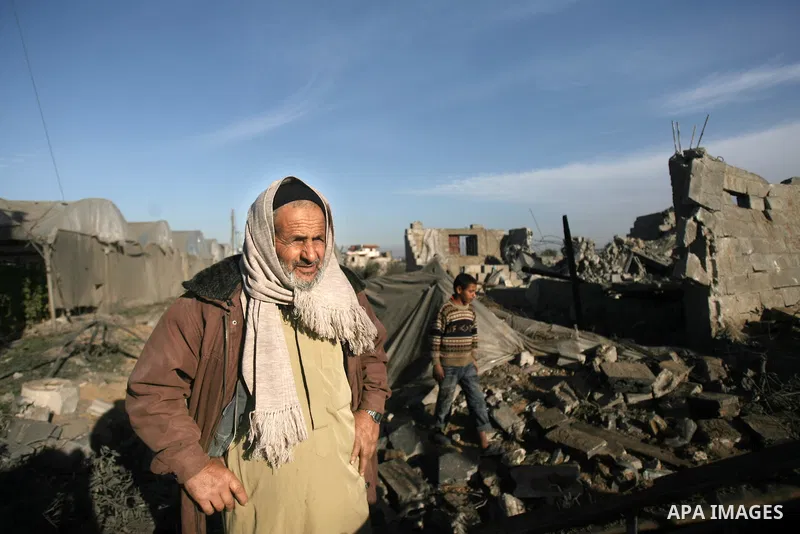 An elderly Palestinian man inspects the rubble of his home following an Israeli air strike that injured two Palestinians, in the southern Gaza Strip town of Rafah on January 31, 2014. Photo by Eyad Al Baba
