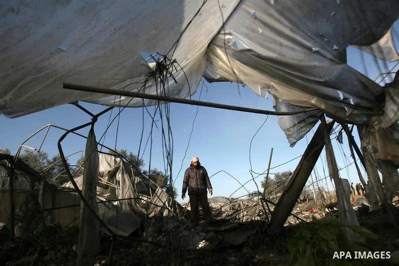 A Palestinian man inspects his farm following an Israeli air strike that injured two Palestinians, in the southern Gaza Strip town of Rafah on January 31, 2014. Photo by Eyad Al Baba