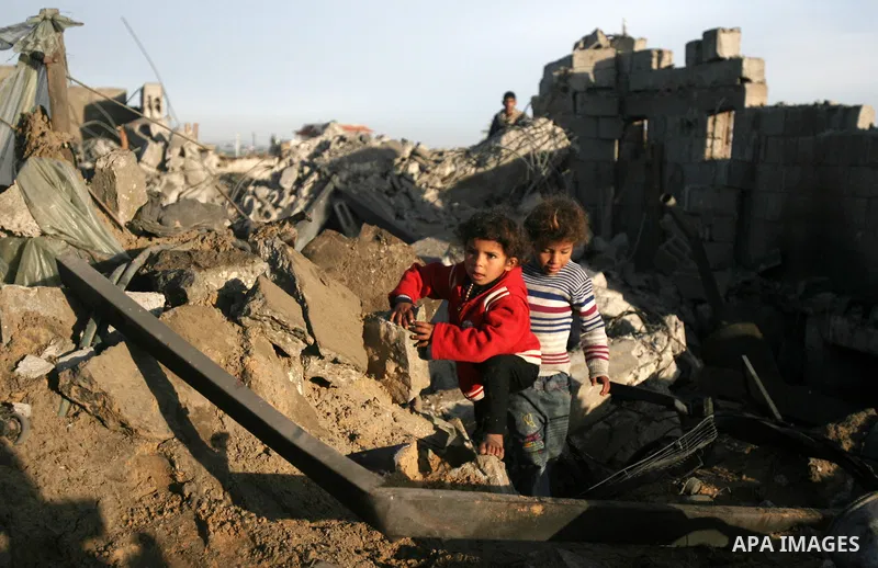 Palestinian children inspect the damage done to a house following an Israeli air strike that injured two Palestinians, in the southern Gaza Strip town of Rafah on January 31, 2014. Photo by Eyad Al Baba