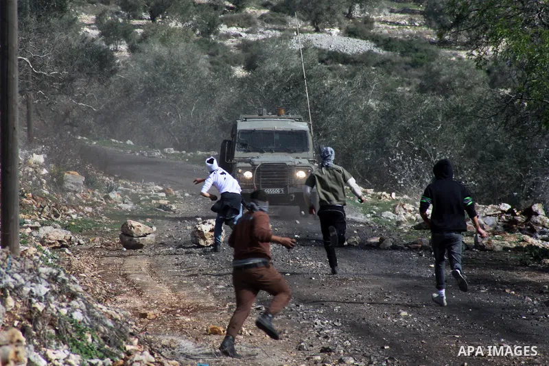Palestinian protesters throw stones at Israeli security forces as clashes broke out during a demonstration against the expropriation of Palestinian land by Israel in the village of Kfar Qaddum, near the occupied West Ban...