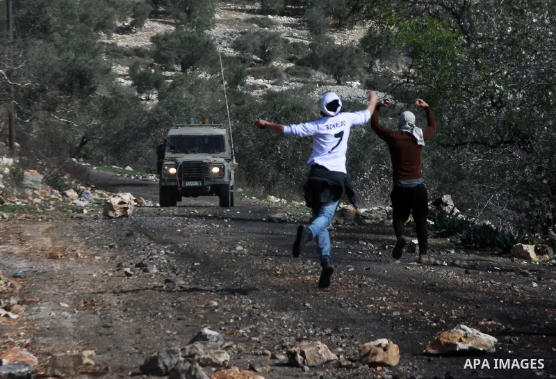 Palestinian protesters throw stones at Israeli security forces as clashes broke out during a demonstration against the expropriation of Palestinian land by Israel in the village of Kfar Qaddum, near the occupied West Ban...