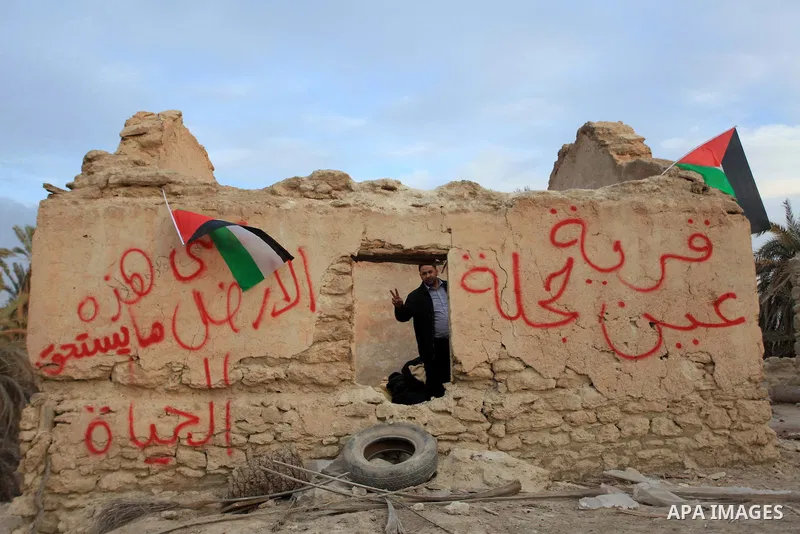 A Palestinian activist flashes a victory sign at the site of the old village known as Ein Hijleh, in the Jordan valley near the West Bank City of Jericho, January 31, 2014. Hundreds of Palestinians announced today the la...