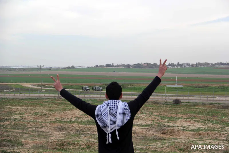 A Palestinian protester flashes victory sign during clashes with Israeli forces near the border with Israel, east of Jabalia refugee camp in northern Gaza Strip on January 31, 2014. The Israeli army fired live rounds and...