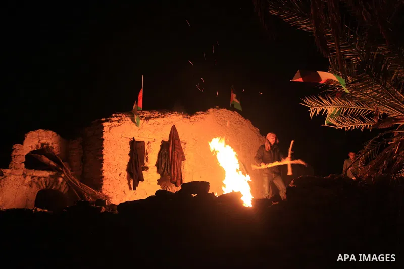 Palestinian and foreign activists warm themselves around a fire at the site of the old village known as Ein Hijleh, in the Jordan valley near the West Bank City of Jericho, January 31, 2014. Hundreds of Palestinians anno...