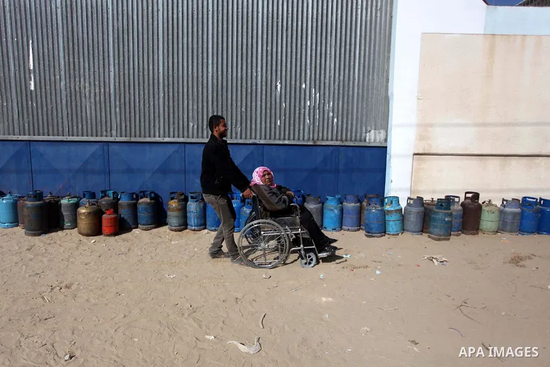 Palestinians wait in line to refill cooking gas bottles at a warehouse in Deir al-Balah center Gaza Strip on Feb. 01, 2014. Photo by Ashraf Amra