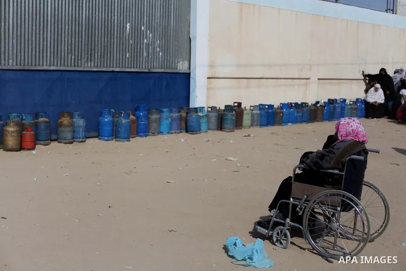 A Palestinian woman waits in line to refill cooking gas bottles at a warehouse in Deir al-Balah center Gaza Strip on Feb. 01, 2014. Photo by Ashraf Amra