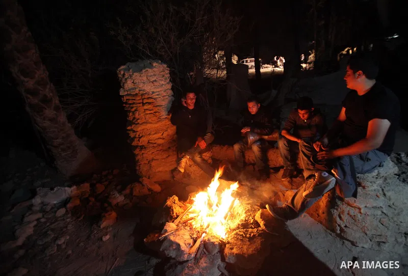 Palestinian and foreign activists warm themselves beside a fire at the site of the old village known as Ein Hijleh, in the Jordan valley near the West Bank City of Jericho Feb. 01, 2014. Hundreds of Palestinians announce...