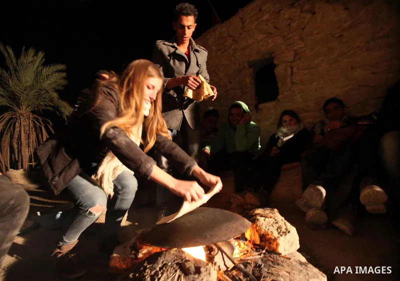 A foreign activist bakes bread at the site of the old village known as Ein Hijleh, in the Jordan valley near the West Bank City of Jericho Feb. 01, 2014. Hundreds of Palestinians announced today the launching of the Melh...
