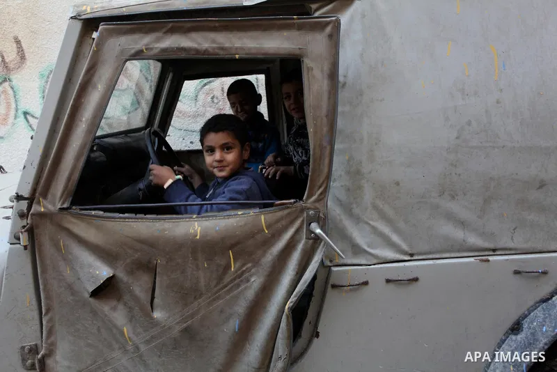 Palestinian children play in a car outside their family's houses at al-Shati refugee camp, in the west Gaza City on February 02, 2014. Photo by Ashraf Amra