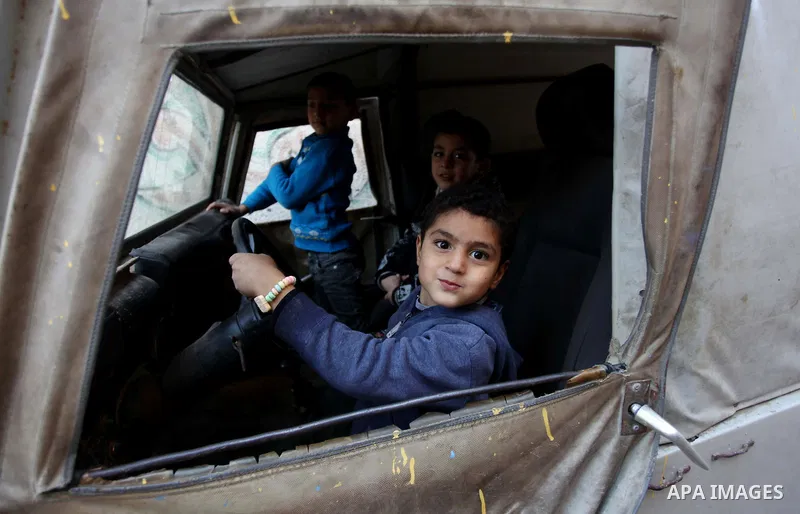 Palestinian children play in a car outside their family's houses at al-Shati refugee camp, in the west Gaza City on February 02, 2014. Photo by Ashraf Amra