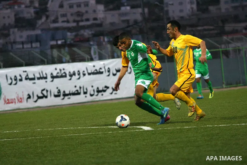 Palestinian players of al-Dahriya Youth Club (green) compete against Kyrgyz team Olay Osh (yellow) during the preliminary round of Asian Football Confederation (AFC) Cup, in the West Bank City of Hebron, February 02, 201...