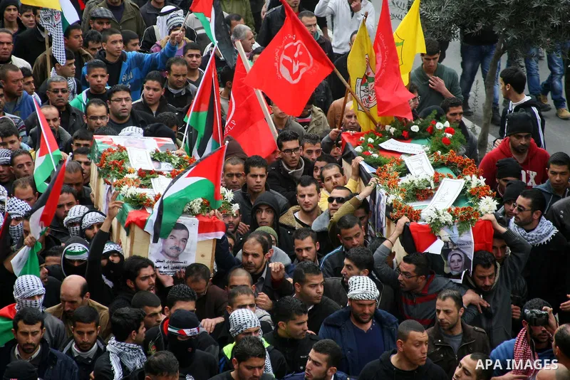 Palestinians carry coffins containing the remains of Ayat al-Akhras and Daoud Abu Swai during their funeral in Deheishe refugee camp in the West Bank town of Bethlehem February 3, 2014. Last month, Israel began to exhume...