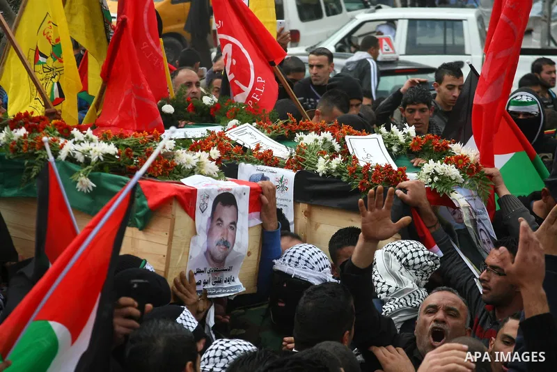 Palestinians carry coffins containing the remains of Ayat al-Akhras and Daoud Abu Swai during their funeral in Deheishe refugee camp in the West Bank town of Bethlehem February 3, 2014. Last month, Israel began to exhume...