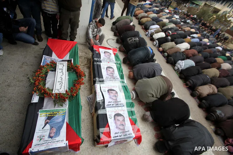 Palestinians pray on the coffins containing the remains of Ayat al-Akhras and Daoud Abu Swai during their funeral in Deheishe refugee camp in the West Bank town of Bethlehem February 3, 2014. Last month, Israel began to...