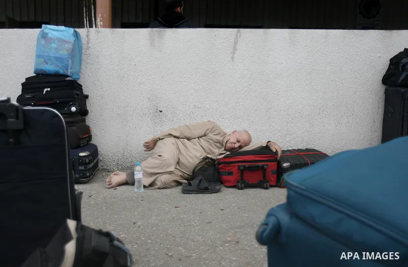 A Palestinian man sleeps as waits to cross into Egypt, at Rafah crossing between Egypt and the southern Gaza Strip February 4, 2014. Egyptian authorities partially opened the Rafah crossing, Gaza's main window to the wor...