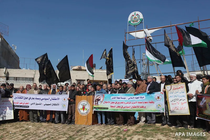 Palestinian of Islamic Jihad hold Palestinian flags and pictures of prisoners during a protest in solidarity with sick prisoners in Israeli jails in Gaza City, on Feb. 05, 2014. Photo by Ashraf Amra