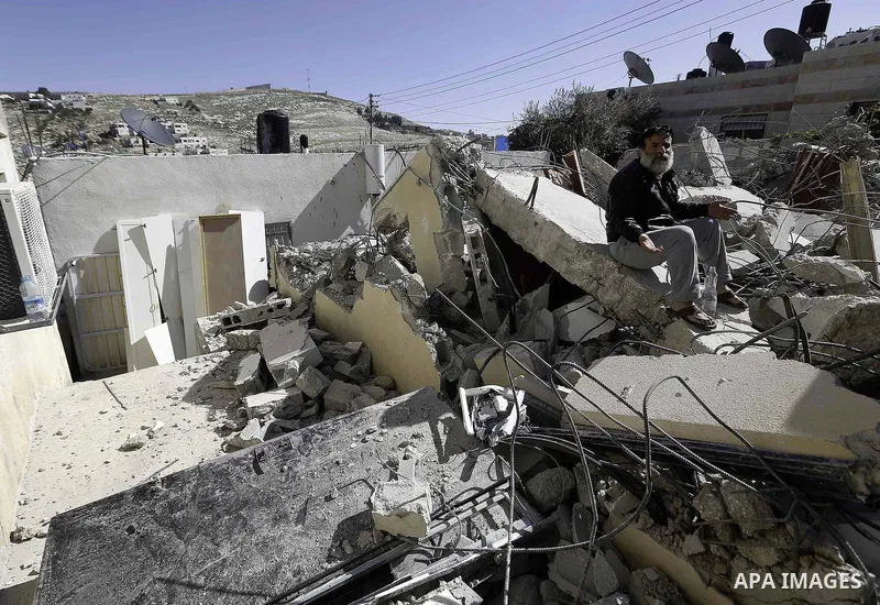 A Palestinian man sits on the rubble of his house after it was demolished by Israeli municipality diggers that the authorities believe without municipal permission in Jabal al-Mukabbir neighborhood south Jerusalem, on Fe...