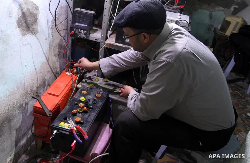 Palestinian Hassan Saad, 35, works at a small workshop in his house in Shijaiya, in Gaza City on Feb. 05, 2014. Saad using damaged car batteries after rehabilitation for lighting dozens of homes at his neighborhood durin...