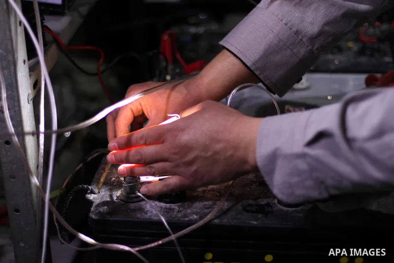 Palestinian Hassan Saad, 35, works at a small workshop in his house in Shijaiya, in Gaza City on Feb. 05, 2014. Saad using damaged car batteries after rehabilitation for lighting dozens of homes at his neighborhood durin...