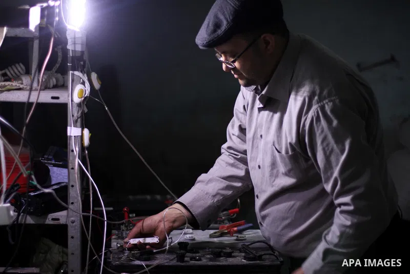 Palestinian Hassan Saad, 35, works at a small workshop in his house in Shijaiya, in Gaza City on Feb. 05, 2014. Saad using damaged car batteries after rehabilitation for lighting dozens of homes at his neighborhood durin...