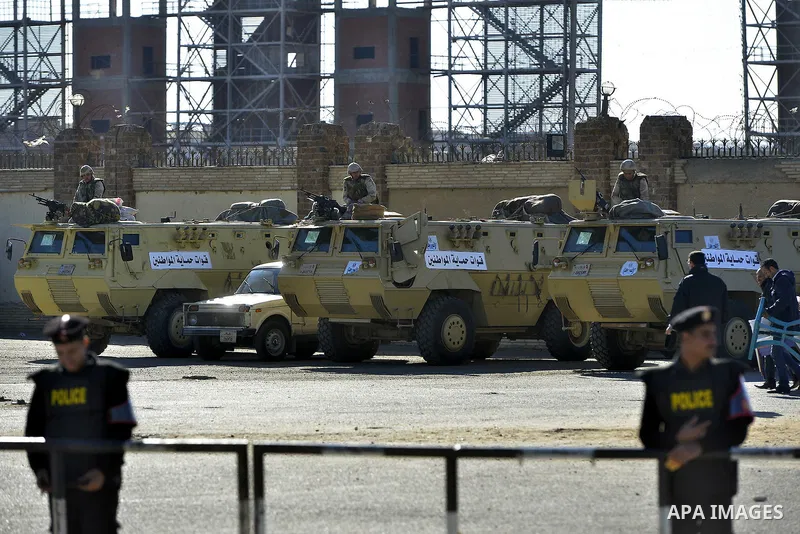 Security forces stand guard as ousted Egyptian president Morsi and 14 other defendants arrive at Cairo's Police Academy. An Egyptian court on Wednesday adjourned the murder trial of ousted president Morsi to 1 March, to...
