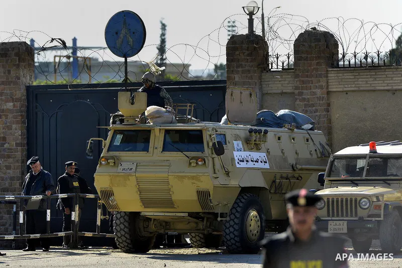 Security forces stand guard as ousted Egyptian president Morsi and 14 other defendants arrive at Cairo's Police Academy. An Egyptian court on Wednesday adjourned the murder trial of ousted president Morsi to 1 March, to...
