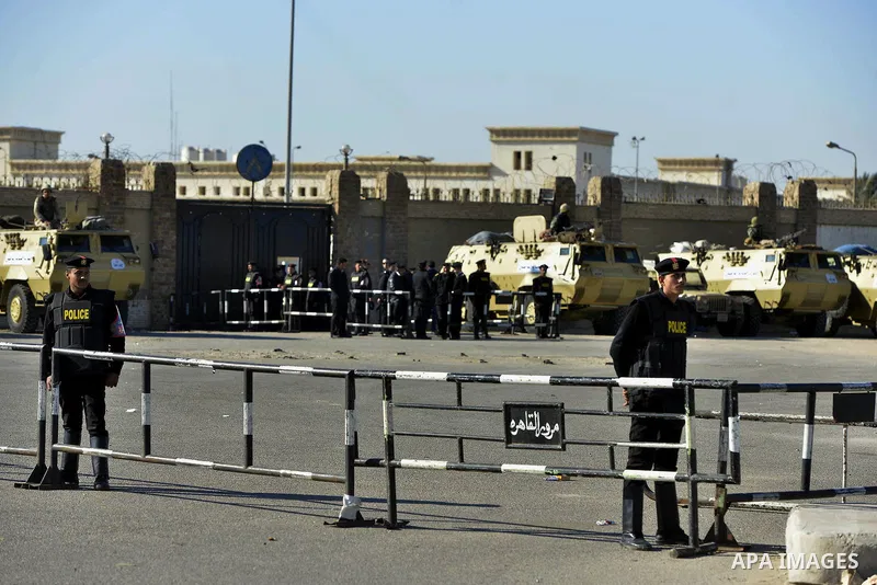 Security forces stand guard as ousted Egyptian president Morsi and 14 other defendants arrive at Cairo's Police Academy. An Egyptian court on Wednesday adjourned the murder trial of ousted president Morsi to 1 March, to...