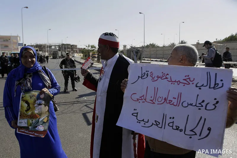 Egyptian supporters of Egypt's army chief Field Marshal Abdel Fattah al-Sisi carry a poster of Sisi in front of riot police outside a police academy, on Feb. 05, 2014. Morsi and 14 co-defendants, some of them former aide...