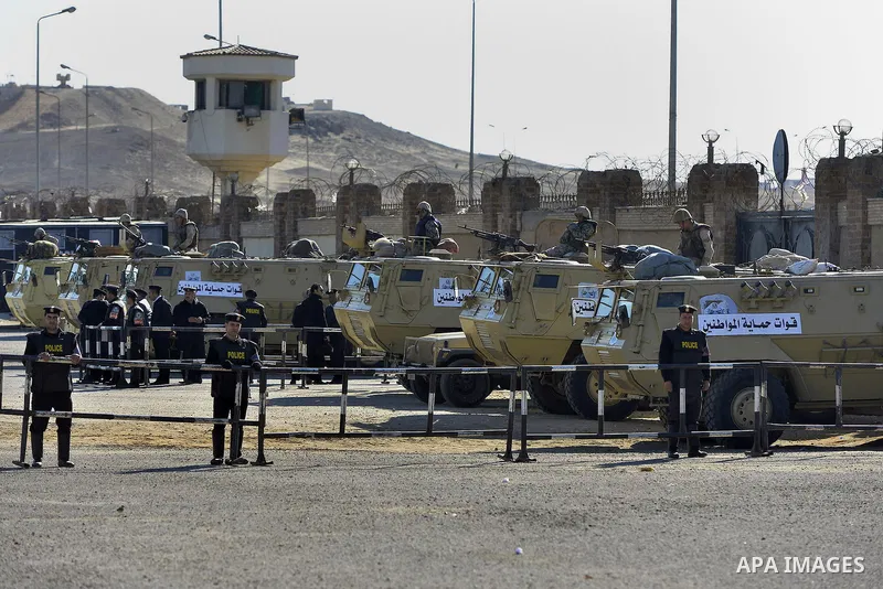 Security forces stand guard as ousted Egyptian president Morsi and 14 other defendants arrive at Cairo's Police Academy. An Egyptian court on Wednesday adjourned the murder trial of ousted president Morsi to 1 March, to...