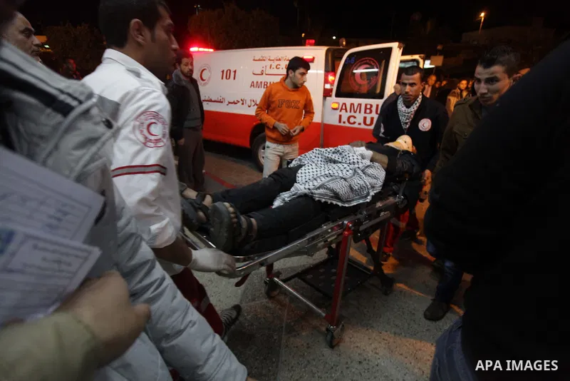 Palestinian medics and relatives look at the lifeless body of Ibrahim al-Saidi, 25, at the morgue of Al-Aqsa hospital in Deir Al Balah, central Gaza Strip, Feb. 07, 2014. A Palestinian was killed and two others were inju...
