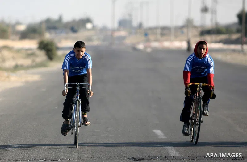 Palestinian youths race the a bicycle in Rafah southern Gaza strip, on Feb. 07, 2014. Photo by Eyad Al Baba