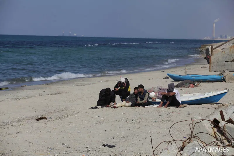 Palestinian men sit at the port in Gaza City on the coast of the Mediterranean Sea on Feb. 08, 2014. Photo by Ashraf Amra