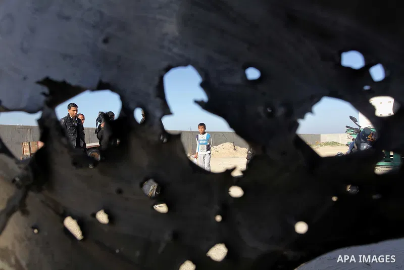 Palestinians look at the scene of an Israeli air strike in the centre of the Gaza Strip February 9, 2014. An Israeli air strike on the Gaza Strip on Sunday critically wounded a Palestinian whom the military said was resp...