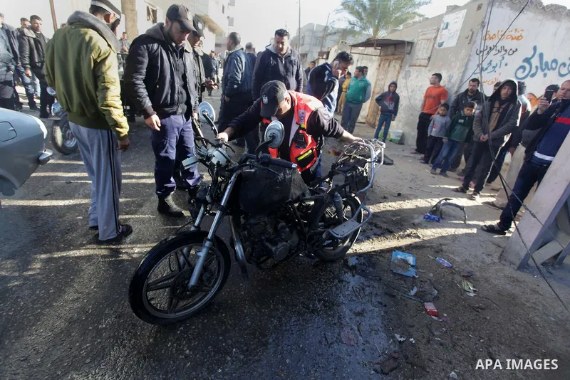Palestinians gather around the wreckage of a motorcycle following an Israeli air strike, in Gaza City, on Feb. 09, 2014. An Israeli air strike on the Gaza Strip on Sunday critically wounded a Palestinian whom the militar...