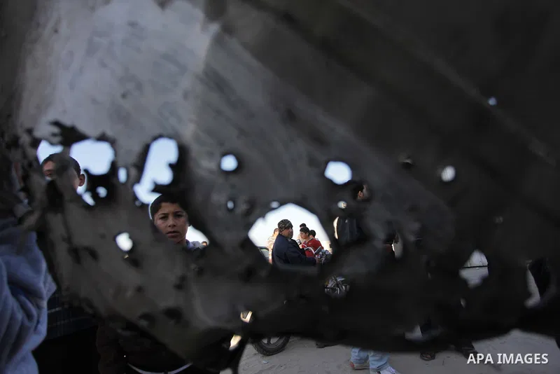 Palestinians look at the scene of an Israeli air strike in the centre of the Gaza Strip February 9, 2014. An Israeli air strike on the Gaza Strip on Sunday critically wounded a Palestinian whom the military said was resp...