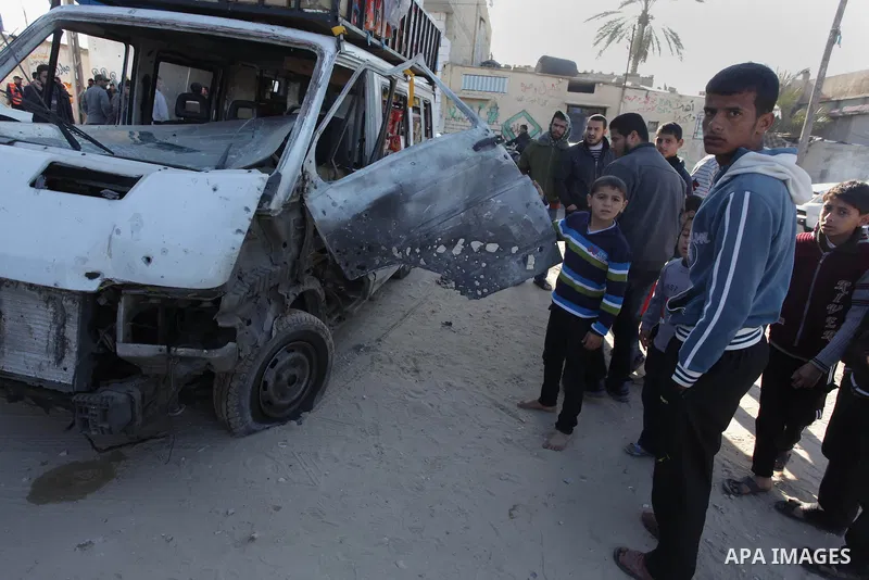 Palestinians gather around the wreckage of a bus following an Israeli air strike, in Gaza City, on Feb. 09, 2014. An Israeli air strike on the Gaza Strip on Sunday critically wounded a Palestinian whom the military said...