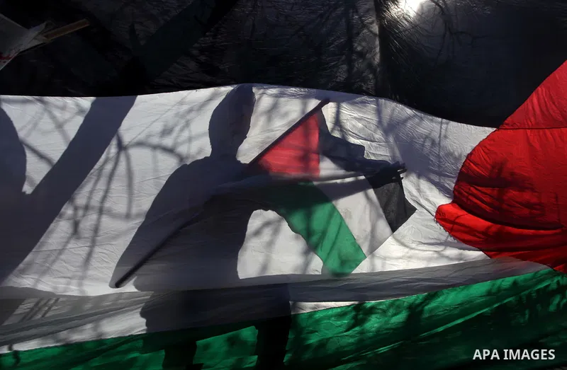 ِِِِِA Palestinian man waves his national flag during a moot court against of the war criminals Prime Minister of Israel Benjamin Netanyahu, and former Prime Minister Ehud Barak in front of the headquarters of the United...