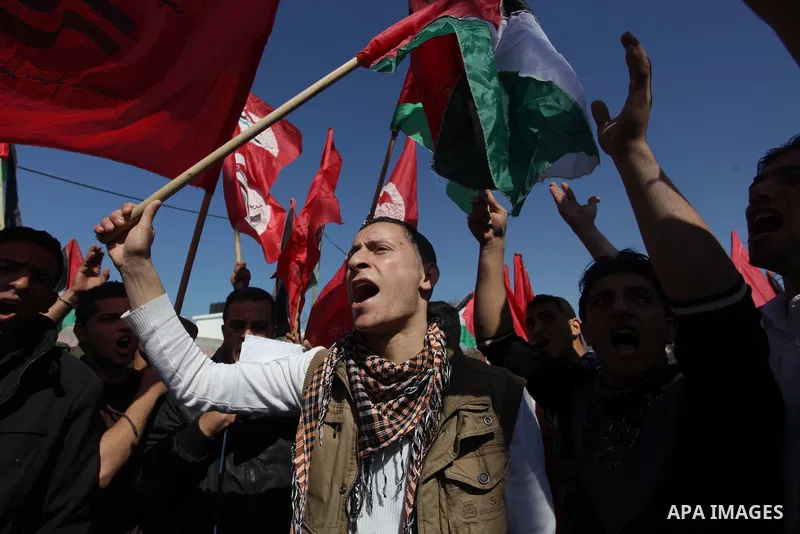 Supporters of Palestinian People's Party wave their national flag during a moot court against of the war criminals Prime Minister of Israel Benjamin Netanyahu, and former Prime Minister Ehud Barak in front of the headqua...