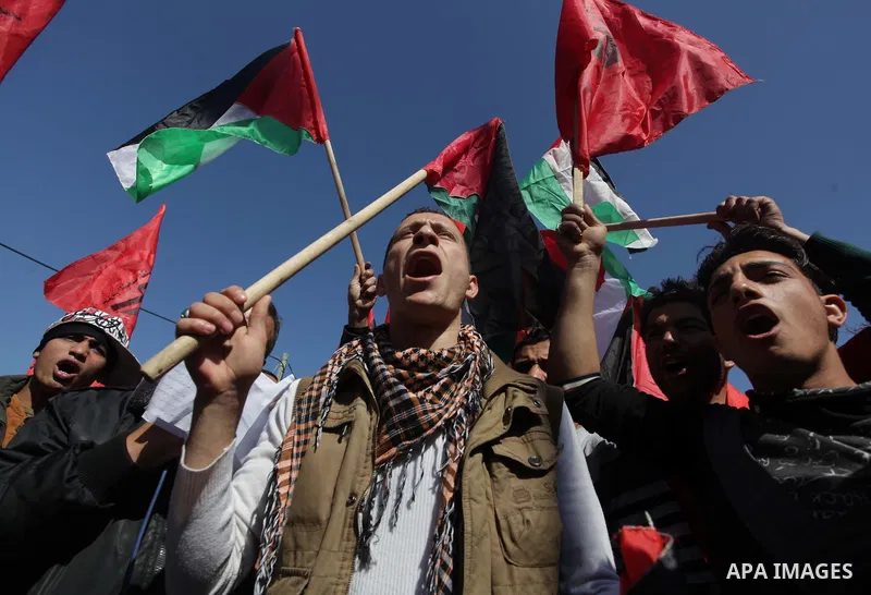 ِِِِِA Palestinian man waves his national flag during a moot court against of the war criminals Prime Minister of Israel Benjamin Netanyahu, and former Prime Minister Ehud Barak in front of the headquarters of the United...