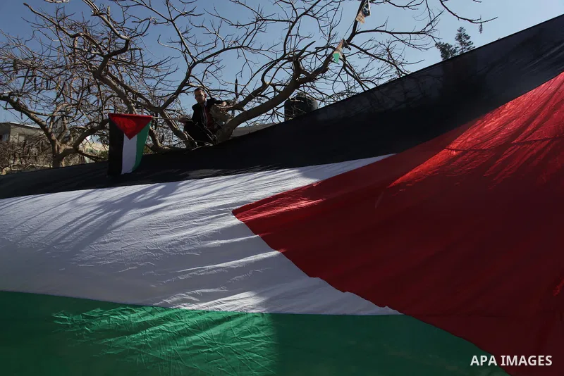 ِِِِِA Palestinian man waves his national flag during a moot court against of the war criminals Prime Minister of Israel Benjamin Netanyahu, and former Prime Minister Ehud Barak in front of the headquarters of the United...