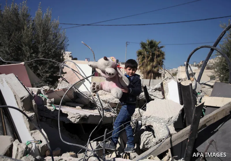 A Palestinian child play on the rubble of his house after it was demolished by Israeli municipality diggers that the authorities believe without municipal permission in the neighborhood of 'Wade advent' of the town of Si...
