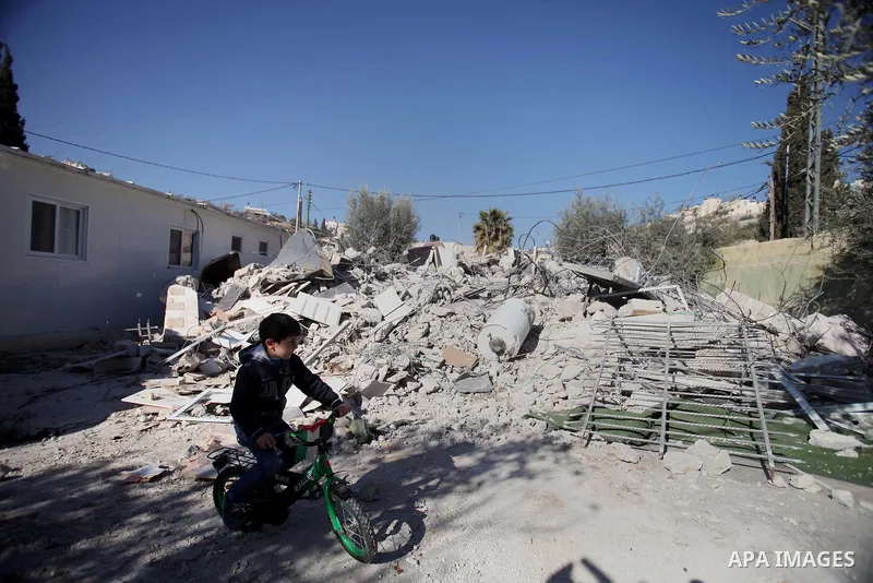 A Palestinian child play on the rubble of his house after it was demolished by Israeli municipality diggers that the authorities believe without municipal permission in the neighborhood of 'Wade advent' of the town of Si...