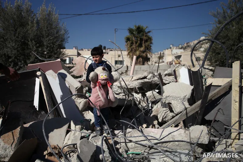 A Palestinian child play on the rubble of his house after it was demolished by Israeli municipality diggers that the authorities believe without municipal permission in the neighborhood of 'Wade advent' of the town of Si...