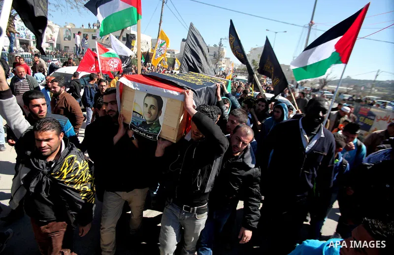Palestinians carry a coffin containing the remains of Ahmed al-Faqih, during a funeral in the West Bank village of Dura, southeast of Hebron, Feb. 10, 2014. Israel on Sunday evening delivered the remains of Ahmad Ayid Fa...