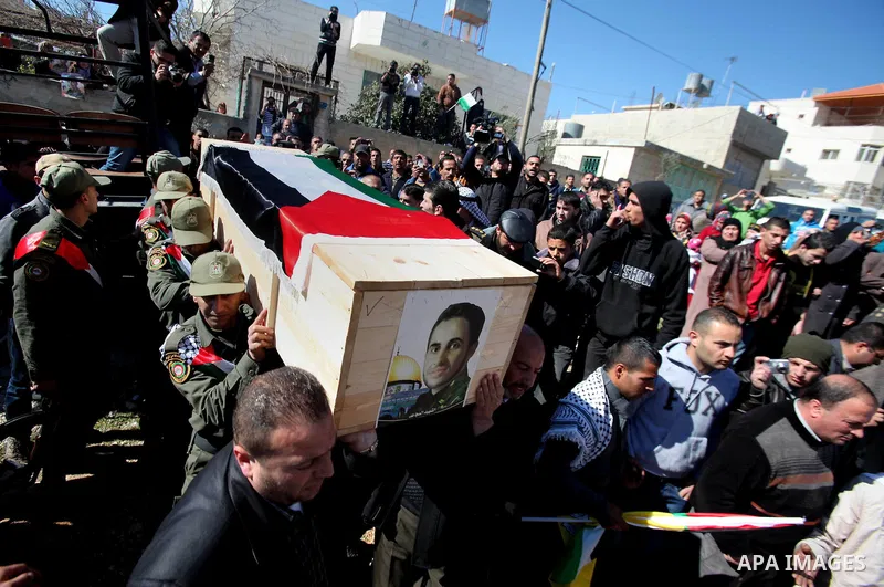 Palestinian security forces carry a coffin containing the remains of Ahmed al-Faqih, during a funeral in the West Bank village of Dura, southeast of Hebron, Feb. 10, 2014. Israel on Sunday evening delivered the remains o...