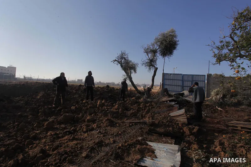 Palestinians inspect the scene of what witnesses said was hit by an Israeli air strike at Nusseirat in the centre of the Gaza Strip February 11, 2014. Photo by Ashraf Amra
