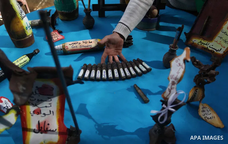 Palestinian Mohammed al-Zomar, 32, displays the remains of Israeli ammunition at his studio in the central Gaza Strip February 12, 2014. Al-Zomar draws and paints on remains of Israeli ammunition that he collected during...