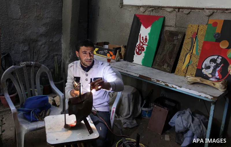 Palestinian Mohammed al-Zomar, 32 works on the remains of Israeli ammunition at his studio in the central Gaza Strip February 12, 2014. Al-Zomar draws and paints on remains of Israeli ammunition that he collected during...