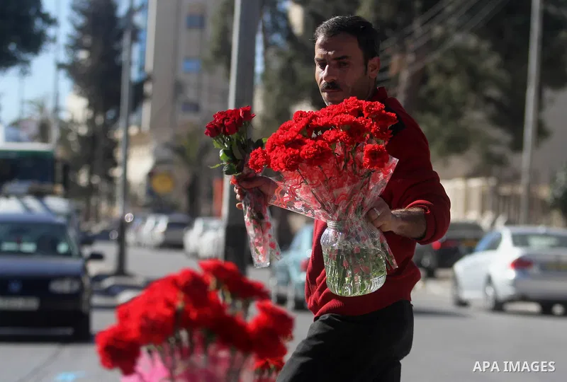 A Palestinian vendor sells a flowers ahead of Valentine's day at streets in the West Bank city of Ramallah, on Feb. 13, 2014. Valentine's Day is increasingly popular among younger Palestinians, many of whom have taken up...