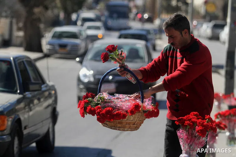 A Palestinian vendor sells a flowers ahead of Valentine's day at streets in the West Bank city of Ramallah, on Feb. 13, 2014. Valentine's Day is increasingly popular among younger Palestinians, many of whom have taken up...